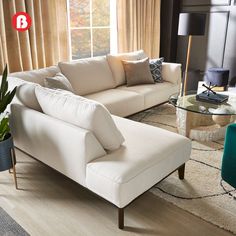 a living room filled with furniture and a large window covered in drapes, next to a coffee table