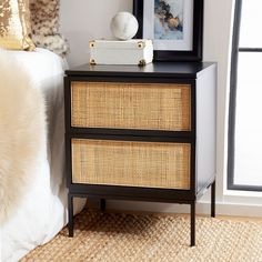 a black and gold dresser with wicker drawers in a bedroom area next to a white bed