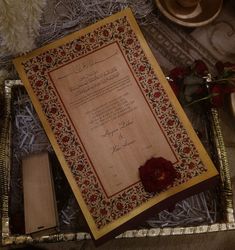 an award certificate sitting on top of a wooden box next to flowers and other items