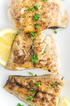 two fish fillets with lemon slices and parsley