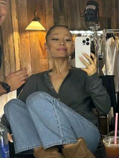 a woman sitting in front of a mirror taking a selfie