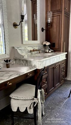 a bathroom with two sinks and a mirror on the wall next to a chair in front of it