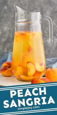 a pitcher filled with peach sangria sitting on top of a table