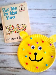 a yellow paper plate with a face on it next to a children's book