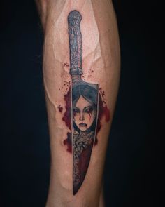 a woman with a knife tattoo on her leg