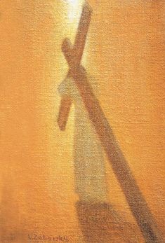 the shadow of a person's hand holding a cross on a yellow background with light coming through it