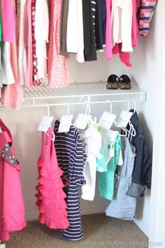 a closet with clothes and shoes hanging on the rack