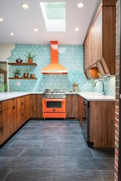 an orange stove top oven sitting inside of a kitchen next to wooden cabinets and counter tops