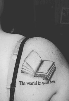 a woman with a book tattoo on her shoulder reading the world is quiet here,