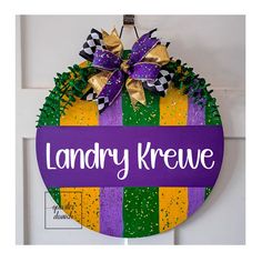 a purple and yellow door hanger with the words laundry krewe on it