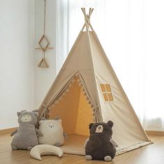 three stuffed animals sitting in front of a teepee