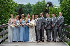 a group of people that are standing on a wooden bridge in front of some trees