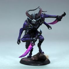 a toy figurine is shown on a white surface with purple and black paint