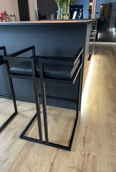 two black chairs sitting next to each other on top of a hard wood floor