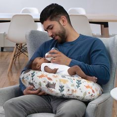 a man sitting in a chair holding a baby