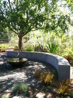 a stone bench sitting next to a tree