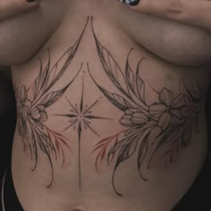 a woman's back with tattoos on her body and flowers in the middle,