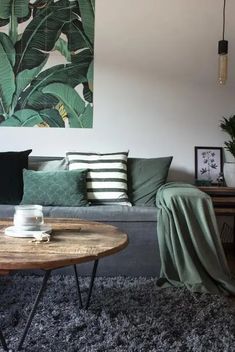 a living room with a couch, coffee table and large painting on the wall behind it