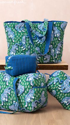 three bags sitting on top of each other in front of a wooden table and bench