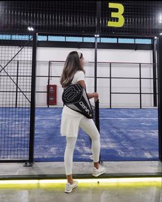 a woman holding a tennis racquet on top of a tennis court