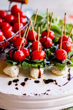 small appetizers are arranged on a plate with toothpicks