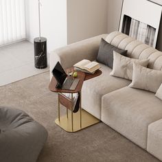 a living room with a couch, coffee table and laptop computer on the end table