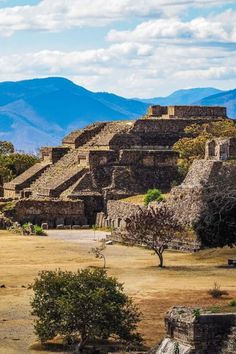 an ancient city in the middle of nowhere with mountains in the backgrouds