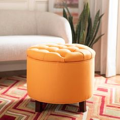 an orange ottoman sitting on top of a rug