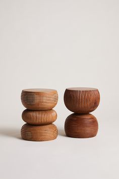 three wooden stools stacked on top of each other in front of a white background