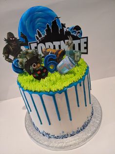 a birthday cake decorated with monsters and other things on the top tier is blue and white icing