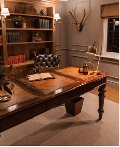 a desk with a chair and bookshelf in the background