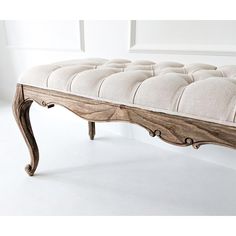 a bench made out of wood and upholstered with white fabric on the seat