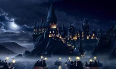 the hogwarts castle is lit up at night with fog and bright lights in the foreground