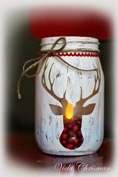 a mason jar filled with raspberries and a deer's head painted on it