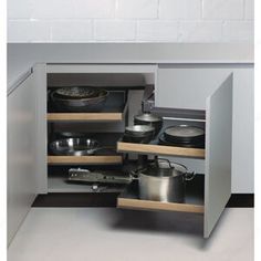 an open cabinet with pots and pans in it