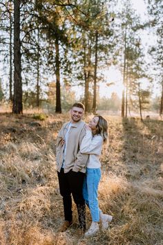 a man and woman are standing in the woods