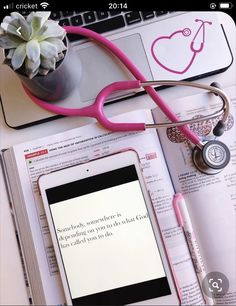 an open book with a stethoscope on top of it next to a laptop