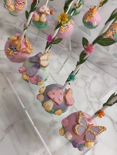 there are many cake pops decorated with flowers and animals on the sticks in the shape of hearts