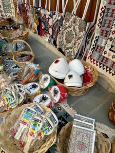 baskets filled with items sitting on top of a floor next to rugs and pillows