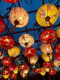 many colorful lanterns are hanging from the ceiling