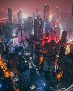 an aerial view of a city at night with lots of tall buildings and skyscrapers