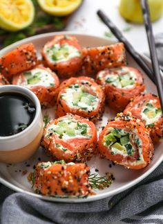 a white plate topped with sushi rolls and dipping sauce