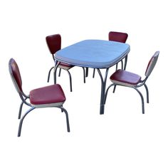 a blue table with four red chairs and one white chair in the middle on a white background