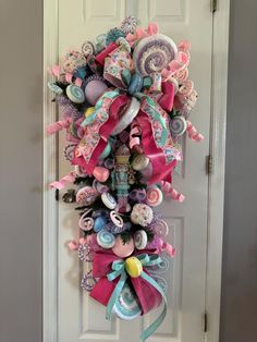 a pink and blue wreath on the front door with lots of hair accessories hanging from it