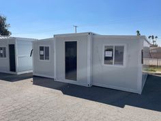 two white portable buildings sitting on top of a parking lot