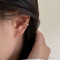 a close up of a person's ear with two small rings on top of it