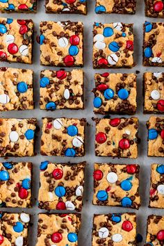 cookies and m & m bars are arranged on a sheet of baking paper with red, white, and blue candies