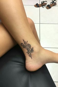 a woman's foot with a flower tattoo on it