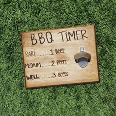 a wooden sign that says bbq timer on it's side in the grass