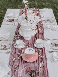 the table is set with plates, silverware and pink napkins for an elegant look